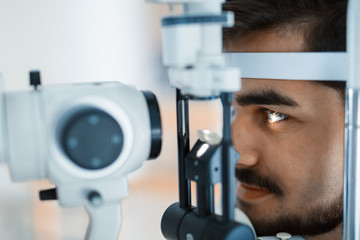 Patient or customer at slit lamp at optometrist or optician