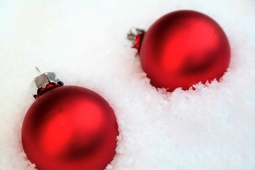 Christmas balls or red ornaments in white snow and text space