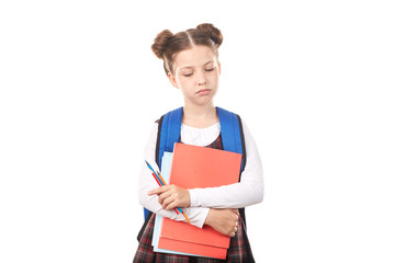 Obraz premium Portrait of girl in school uniform with backpack holding textbooks and pencils and thinking sadly against white background