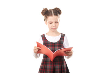 Sad elementary school girl reading book against white background