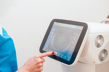 Doctor controls instrument exploring patients eye in ophthalmology clinic, Auto-Ref-Keratometer. Close up, selective focus.