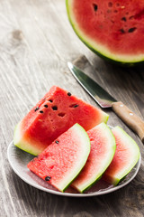 Walermelon pieces on wooden garden table. 