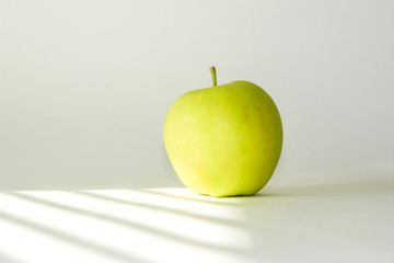 Yellow-green apple on a white background