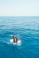 Young man jumping into the water