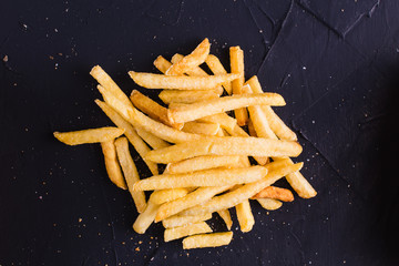 French fries on a dark background (top view)