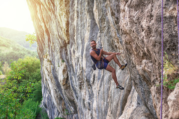 Rock climber bouldering outdoors on mountain in nature