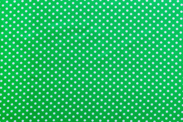 Green polka-dot cotton backdrop directly above