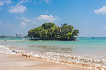 The white sandy beach and bay of Weligama with Taprobane Island in the foreground. Originally called Galduwa in Sinhalese, it means rock island. The beach in the south is very popular with surfers.	