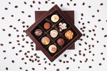 handmade chocolates in a square box and coffee beans around