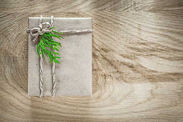 Handmade present box wrapped in brown paper with green branch on