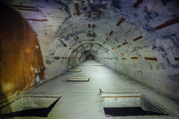 Dangerous tunnel at abandoned Soviet bunker with pits on the floor