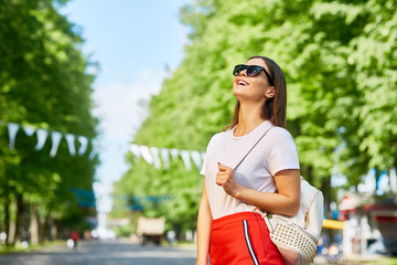 Portrait of beautiful young girl enjoying walk in park on sunny summer day