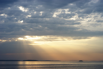 Naklejka na ściany i meble Sunset rays over the ocean landscape background