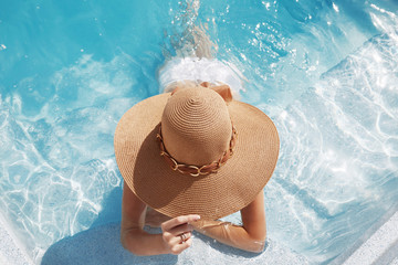Woman in beach hat enjoying in swimming pool on Tropical Resort. Exotic Paradise. Travel, Tourism and Vacations Concept. - obrazy, fototapety, plakaty