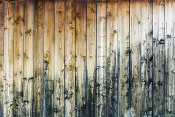 vertical sunburned wooden slats on a mountain cabin wall as a horizontal background