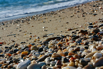 Fototapeta na wymiar Close-up of colourful pebbles on the beach