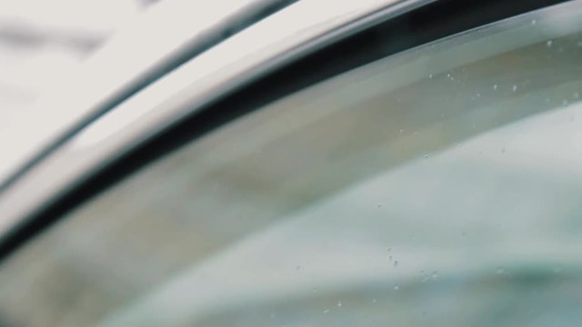 Female driver hand gives SD memory card to man trough slightly open car window outdoors on cold winter day, close up