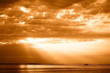 Obraz na płótnie Canvas Sunset rays over the ocean landscape background