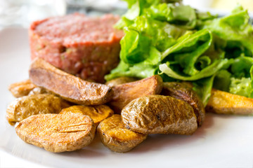 Raw beef classic steak tartare on white plate