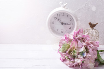 Postcard with pink hydrangea flowers and clock on light textured background.