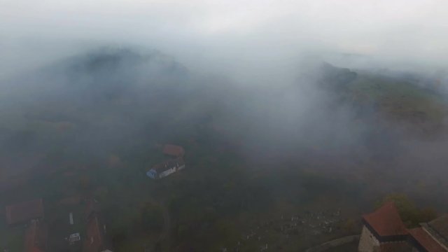 4k aerial drone reveal shot of the fortified church from saxon village Viscri.	Impressive lutheran church appearing through fog in early morning. Transylvania, Romania.