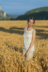 Beautiful woman in wheat at sunset.