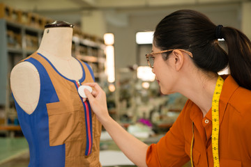 woman tailor holding chalk drawing in dummy