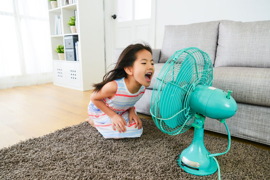 lovely young female children face to electric fan