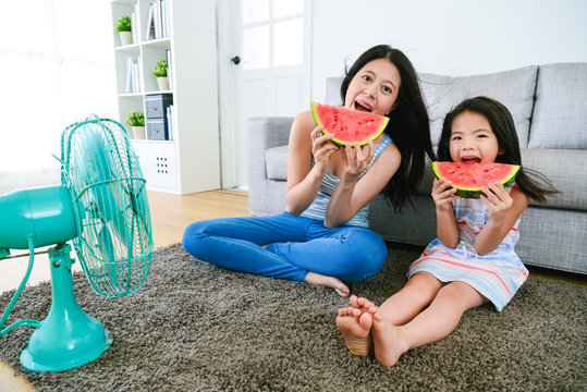 beautiful mother with daughter eating watermelon