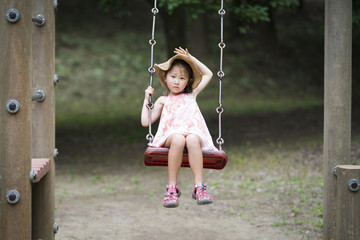 Little girl playing with swing