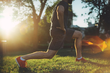 Young man doing stretch exercises muscles before training