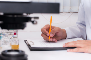 Scientist writing result the test in laboratory room. Scientific research