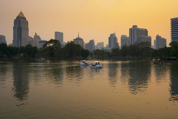 Lumpini park in Bangkok at dusk with tourists are enjoy driving duck boat.