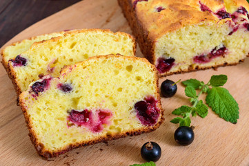 Delicate tasty curd cake with black currant and jam on a dark wooden background.