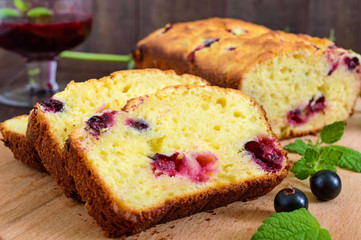 Delicate tasty curd cake with black currant and jam on a dark wooden background.