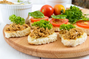 Canapé with chicken liver on a cutting board. Snacks.
