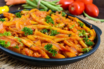 Spicy  green beans stewed with onions, carrots in tomato sauce. Serve on a cast-iron frying pan