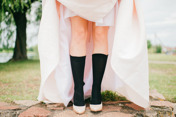 Unrecognizable woman legs in men black socks and high heels shoes.  Unknown odd strange bride in...