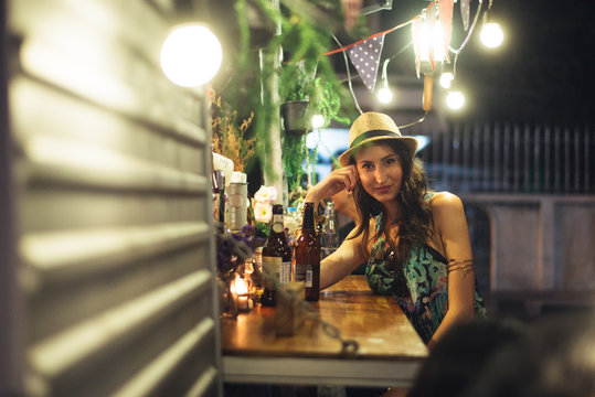 Single Young Woman Sitting At The Food Truck Counter With Beer