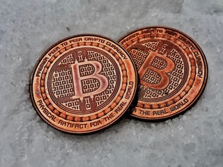 Two very old brass bitcoins