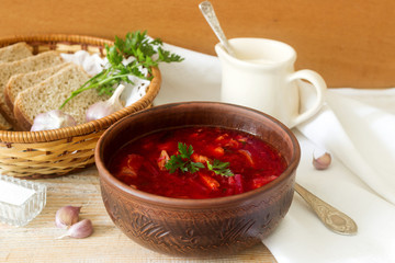 A traditional dish of Russian and Ukrainian cuisine - borsch. Soup with beets, meat, potatoes and beans. Served with sour cream and garlic.