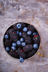 Berry Fresh in a copper cup on the Metal Background. Blackberries,Blueberry.Food or Healthy diet concept.Super Food.Vegetarian.Copy space for Text.selective focus.