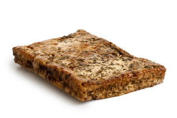 Single block of marinated tofu with herbs  isolated on white.