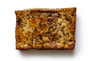 Single block of marinated tofu with herbs  isolated on white from above.