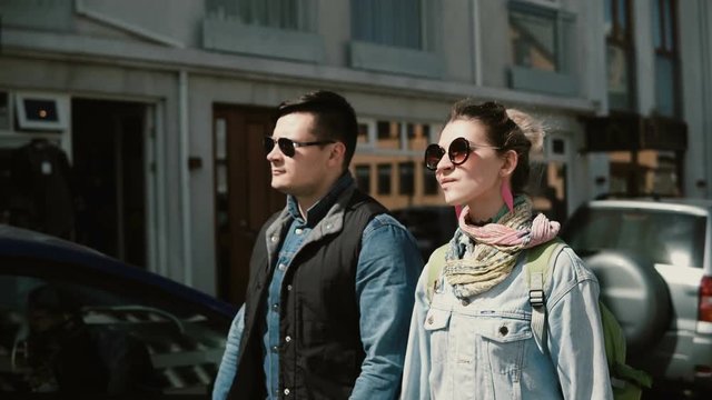 Young beautiful couple walking in the Reykjavik, Iceland and looking around. Man and woman near Hallgrimskirkja church.