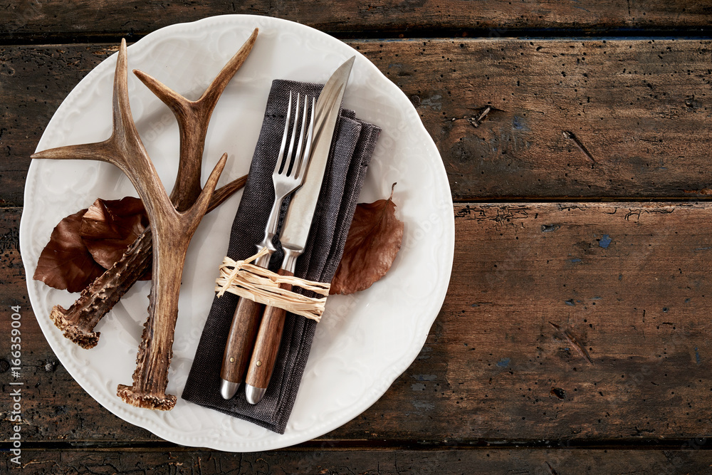 Wall mural deer antlers with cutlery on plate