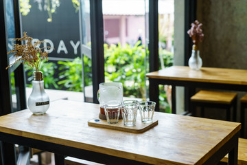 brew coffee in jar with glasses on wood table at cafe