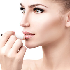 Beautiful woman applying hygienic lip balm.