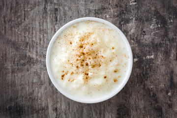 Arroz con leche. Rice pudding with cinnamon on wooden background
