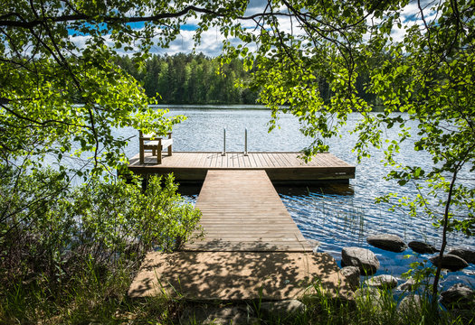 Idyllic lake view with pier at bright sunny summer day.